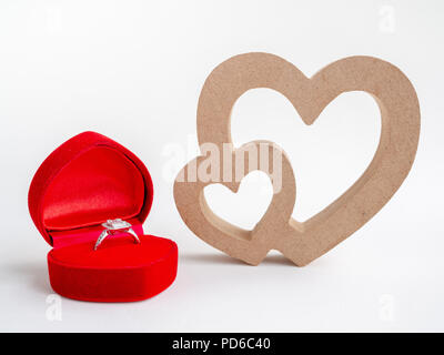 Diamond Ring in Rot Herzform Box und Holz-/Herz, Paar Herz auf weißem Hintergrund. Liebe, Hochzeit, Familie, zum Valentinstag Konzept. Stockfoto