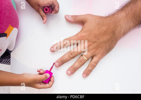 Mädchen bereit Väter Nägel zu rosa Farbe Stockfoto