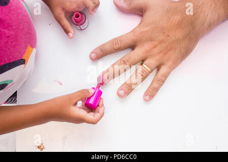 Mädchen Malerei Väter Nägel pink, fehlt die Nägel und Malerei die Finger. Stockfoto