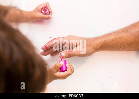 Mädchen Malerei Väter Nägel pink, fehlt die Nägel und Malerei die Finger. Stockfoto