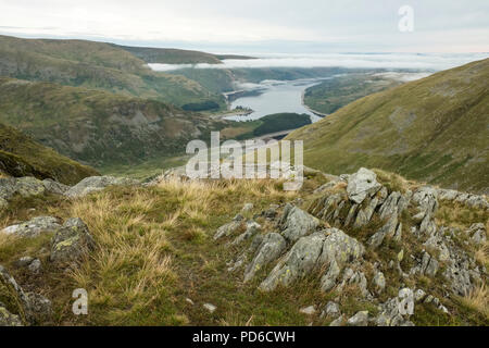 Ansicht aus einem Felsen auf Harter fiel im Lake District. Eine niedrige Haweswater Reservoir in der Ferne und niedrige Wolke, auf halber Höhe des Fells Stockfoto