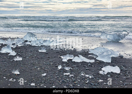 Diamond Beach, South Island, wo Eis von Gletschersee Jökulsárlón Gletscherlagune auf der vulkanischen schwarzen Sand abgelagert wird. Stockfoto