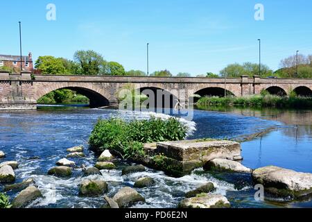 Blick über Geröll und das Wehr in Richtung der Trent Bridge Road Bridge A511 über den Fluss Trent, Burton upon Trent, Staffordshire, England, UK, Benachrichtigen Stockfoto