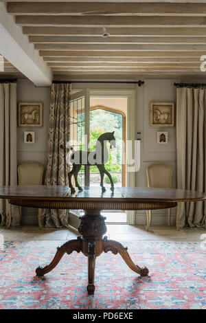 Reiterstandbild auf dem ovalen Esstisch in der Eingangshalle mit offener Tür. Stockfoto