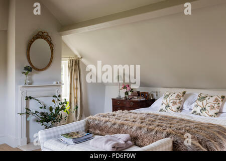 Leaf Arrangement im Zimmer im Dachgeschoss mit Doppelbett und Pelz. Stockfoto