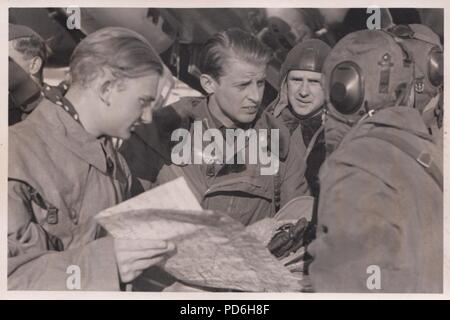 Bild aus dem Fotoalbum von Oberleutnant Oscar Müller von kampfgeschwader 1: Leutnant Oscar Müller (Mitte) im Gespräch mit Leutnant Maier und andere bodenpersonal in der 5./KG 1 am Dno Flugplatz, Russland 1942. Müller's Beobachter, Feldwebel Alfred Koltermann, schaut, über Links Müller's Schulter. Stockfoto