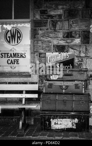 Alte Koffer und historische Werbung im Bodmin und Wenford Bahnhof Stockfoto