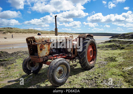 Ein Old David Brown Traktor an einem Strand in der Nähe von Abersoch nahm früher Boote zum Wasser. Dieses Fahrzeug rostet, ist aber immer noch in Ordnung. Stockfoto