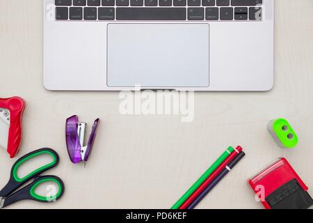 Papier - Werkzeuge der Bleistift, Hefter, Schere, Bleistiftspitzer und moderne Notebook auf hölzernen Tisch. Top Aussicht Stockfoto