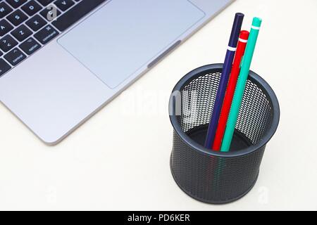 Modernen Laptop und Bunte Bleistifte in Halter auf hellem Holztisch. Zurück zu Schule Konzept Hintergrund Stockfoto