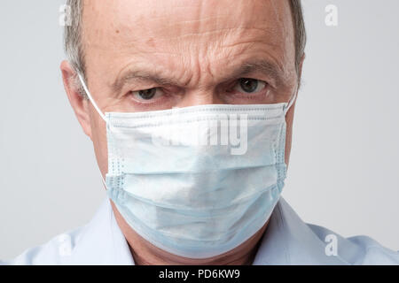 Close up Portrait von ernster Mann in speziellen medic Maske. Er ist auf der Suche ernst. Reifen erfahrenen Arzt. Medizin, Gesundheitswesen und Not in hospit Stockfoto