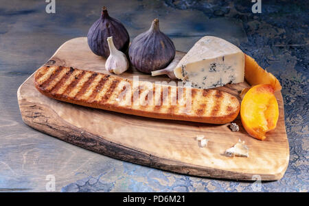 Reifen Feigen, edle Käse mit Schimmel, Pfirsich Schichten und Baguette auf einem Schneidebrett. Stockfoto