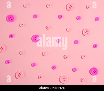 Flach Draufsicht rosa Schaltflächen Muster auf Pastell rosa Hintergrund isoliert Stockfoto