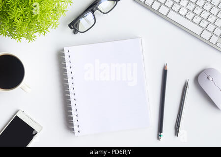 Weiß Schreibtisch im Büro mit Laptops, Smartphones und andere Arbeiten mit einer Tasse Kaffee. Ansicht von oben mit der Kopie Platz für die Eingabe des Textes. Designer Arbeitsbereich Stockfoto