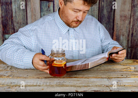 Ein Mann mittleren Alters Studieren und Lesen der Bibel Stockfoto