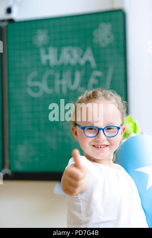 Schülerin am ersten Tag der Schule mit einer Süßigkeit Kegel Stockfoto