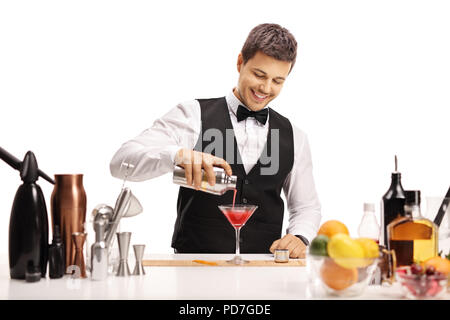 Barkeeper Gießen seine Unterschrift Cocktail in einem Glas auf weißem Hintergrund Stockfoto