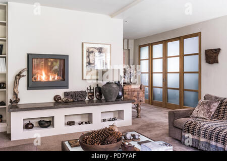 Opak Schiebetüren in Wohnzimmer mit Indischen wolle Teppich von Jacaranda aus Kendal hochwertige Teppiche. Ein Dru Gas Feuer hat in die Wand über eingestellt Stockfoto