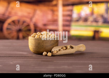 Menge ganze roh Kichererbsen kabuli Sorte mit Holzschale mit Karre im Hintergrund Stockfoto