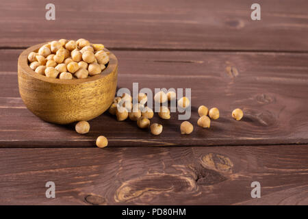 Menge ganze roh Kichererbsen kabuli Sorte mit Houten auf braunem Holz Stockfoto