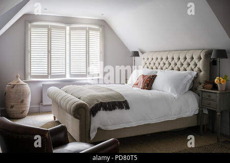 Pentlow knöpfbare Doppelbett aus Sofas und Material im Schlafzimmer mit Nachttischen von Cassia Bardoe Interior Design Stockfoto