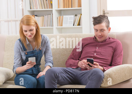 Junges Paar mit ihren Smartphones zu Hause Stockfoto