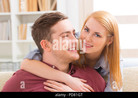 Lächelnde junge Frau liebt Hörstörungen Mann Stockfoto