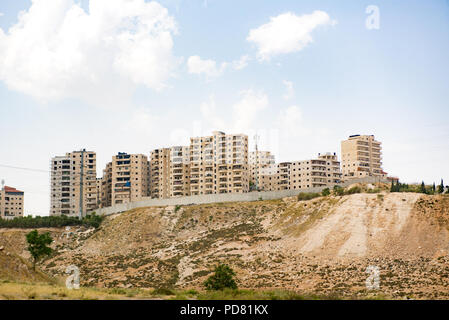 Blick vom Toten Meer Jerusalem Straße in der West Bank palästinensische Gebiet der Trennmauer, hier eine hohe Betonmauer, und Israelische apartment Stockfoto