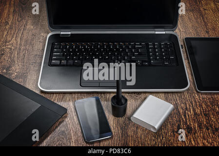 Ansicht von oben Büro Schreibtisch mit Laptop, Mobiltelefon, Grafik Tablett mit Stift und Power Bank Stockfoto