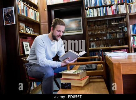 Hamburg, Deutschland. 19 Juni, 2018. Hendrik Heetlage, Geschichte Studentin, schaut auf Bücher, die in der Studie des ehemaligen Bundeskanzlers Helmut Schmidt. Heetlage zieht Bilanz über die Situation im Haus des ehemaligen Bundeskanzler, der im Jahr 2015 gestorben. (Über Tudenten der dpa Vorräte Haus von Helmut Schmidt in Langenhorn" vom 07.08.2018) Credit: Daniel Bockwoldt/dpa/Alamy leben Nachrichten Stockfoto