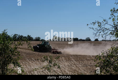 Berlin, Deutschland. 07 Aug, 2018. 07.08.2018, Berlin: der Landwirt lockert den Boden auf seinem Feld mit einer Egge an einem Traktor. Credit: Paul Zinken/dpa/Alamy leben Nachrichten Stockfoto