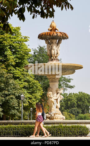 Madrid, Spanien - 7 August 2018: Zwei Damen, die den sommer genießen, Wandern Vor einem Brunnen im Parque del Retiro in Madrid an einem Tag, wenn die Temperaturen 37 C erreicht. Stockfoto