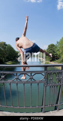 Deutschland, Hannover. 07 Aug, 2018. Ein junger Mann springt über Kopf von einer Brücke in die hannover-linden Kanal abkühlen. Das Wasser- und Schifffahrtsamt für den Kanal in Braunschweig verantwortlich vor kurzem lenkte die Aufmerksamkeit auf die Gefahren des Badens in den Kanälen. Schwimmen, zum Beispiel, ist 100 Meter vor und nach der Brücke untersagt. Nicht erkennbare Objekte unter der Wasseroberfläche sind auch gefährlich für illegale Brücke Brücken. Credit: Julian Stratenschulte/dpa/Alamy leben Nachrichten Stockfoto