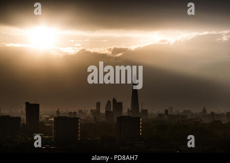 London, Großbritannien. 7. August 2018. UK Wetter: Dramatische abend Sonnenstrahlen über die Stadt Landschaft einschließlich der Shard Wolkenkratzer. Credit: Guy Corbishley/Alamy leben Nachrichten Stockfoto