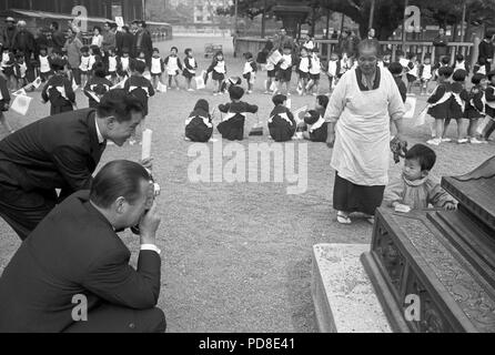 Am 16. November 1963, der deutsche Außenminister Gerhard Schröder (an der Vorderseite) fotografiert von einem kleinen japanischen Jungen während eines Staatsbesuchs in Japan, wo er begleitet hatte Lübke. | Verwendung weltweit Stockfoto