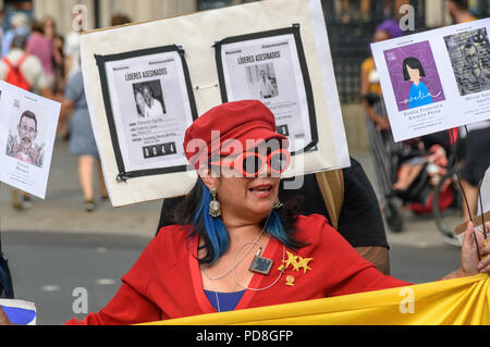 London, Großbritannien. 7. August 2018. Eine kolumbianische Frau hält die Flagge und Plakate mit Bildern von einigen der über hundert ermordet Gemeinschaftsführer bei einem Protest im Parlament Platz zur Unterstützung des Friedensprozesses in Kolumbien und fordert ein Ende der täglichen Drohungen und Morde im ganzen Land.Ook Platz heute bei der UNO in New Y Credit: Peter Marschall/Alamy leben Nachrichten Stockfoto