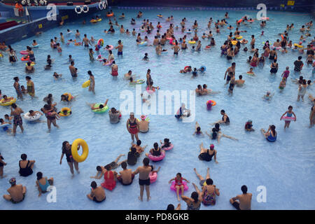 Peking, Peking, China. 8 Aug, 2018. Peking, China - Menschen genießen Sie die kühle am Wasser Park von Beijing National Aquatics Centre in Peking, China. Die Pekinger National Aquatics Center, auch als das Wasser Cube genannt, ist ein schwimmzentrum, die neben Peking Nationalstadion in der Olympischen Grün für die Schwimmwettbewerbe der Olympischen Sommerspiele 2008 errichtet wurde. Trotz seiner Spitznamen, das Gebäude ist nicht eine tatsächliche Cube, aber ein Quader (ein rechteckiger Kasten) Credit: SIPA Asien/ZUMA Draht/Alamy leben Nachrichten Stockfoto