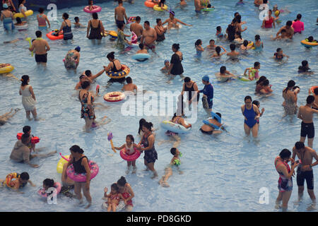 Peking, Peking, China. 8 Aug, 2018. Peking, China - Menschen genießen Sie die kühle am Wasser Park von Beijing National Aquatics Centre in Peking, China. Die Pekinger National Aquatics Center, auch als das Wasser Cube genannt, ist ein schwimmzentrum, die neben Peking Nationalstadion in der Olympischen Grün für die Schwimmwettbewerbe der Olympischen Sommerspiele 2008 errichtet wurde. Trotz seiner Spitznamen, das Gebäude ist nicht eine tatsächliche Cube, aber ein Quader (ein rechteckiger Kasten) Credit: SIPA Asien/ZUMA Draht/Alamy leben Nachrichten Stockfoto