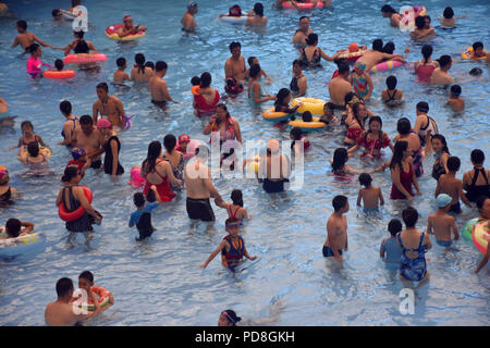 Peking, Peking, China. 8 Aug, 2018. Peking, China - Menschen genießen Sie die kühle am Wasser Park von Beijing National Aquatics Centre in Peking, China. Die Pekinger National Aquatics Center, auch als das Wasser Cube genannt, ist ein schwimmzentrum, die neben Peking Nationalstadion in der Olympischen Grün für die Schwimmwettbewerbe der Olympischen Sommerspiele 2008 errichtet wurde. Trotz seiner Spitznamen, das Gebäude ist nicht eine tatsächliche Cube, aber ein Quader (ein rechteckiger Kasten) Credit: SIPA Asien/ZUMA Draht/Alamy leben Nachrichten Stockfoto