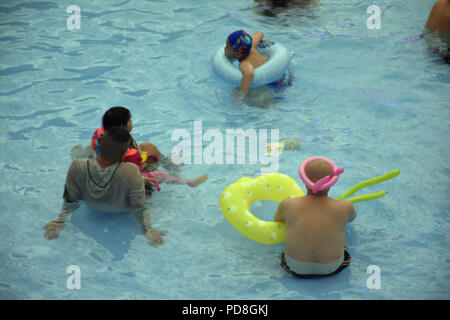 Peking, Peking, China. 8 Aug, 2018. Peking, China - Menschen genießen Sie die kühle am Wasser Park von Beijing National Aquatics Centre in Peking, China. Die Pekinger National Aquatics Center, auch als das Wasser Cube genannt, ist ein schwimmzentrum, die neben Peking Nationalstadion in der Olympischen Grün für die Schwimmwettbewerbe der Olympischen Sommerspiele 2008 errichtet wurde. Trotz seiner Spitznamen, das Gebäude ist nicht eine tatsächliche Cube, aber ein Quader (ein rechteckiger Kasten) Credit: SIPA Asien/ZUMA Draht/Alamy leben Nachrichten Stockfoto