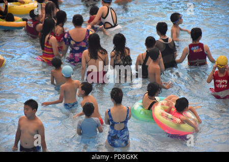 Peking, Peking, China. 8 Aug, 2018. Peking, China - Menschen genießen Sie die kühle am Wasser Park von Beijing National Aquatics Centre in Peking, China. Die Pekinger National Aquatics Center, auch als das Wasser Cube genannt, ist ein schwimmzentrum, die neben Peking Nationalstadion in der Olympischen Grün für die Schwimmwettbewerbe der Olympischen Sommerspiele 2008 errichtet wurde. Trotz seiner Spitznamen, das Gebäude ist nicht eine tatsächliche Cube, aber ein Quader (ein rechteckiger Kasten) Credit: SIPA Asien/ZUMA Draht/Alamy leben Nachrichten Stockfoto