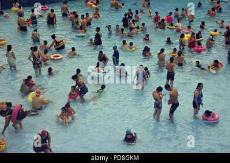 Peking, Peking, China. 8 Aug, 2018. Peking, China - Menschen genießen Sie die kühle am Wasser Park von Beijing National Aquatics Centre in Peking, China. Die Pekinger National Aquatics Center, auch als das Wasser Cube genannt, ist ein schwimmzentrum, die neben Peking Nationalstadion in der Olympischen Grün für die Schwimmwettbewerbe der Olympischen Sommerspiele 2008 errichtet wurde. Trotz seiner Spitznamen, das Gebäude ist nicht eine tatsächliche Cube, aber ein Quader (ein rechteckiger Kasten) Credit: SIPA Asien/ZUMA Draht/Alamy leben Nachrichten Stockfoto