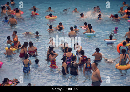 Peking, Peking, China. 8 Aug, 2018. Peking, China - Menschen genießen Sie die kühle am Wasser Park von Beijing National Aquatics Centre in Peking, China. Die Pekinger National Aquatics Center, auch als das Wasser Cube genannt, ist ein schwimmzentrum, die neben Peking Nationalstadion in der Olympischen Grün für die Schwimmwettbewerbe der Olympischen Sommerspiele 2008 errichtet wurde. Trotz seiner Spitznamen, das Gebäude ist nicht eine tatsächliche Cube, aber ein Quader (ein rechteckiger Kasten) Credit: SIPA Asien/ZUMA Draht/Alamy leben Nachrichten Stockfoto