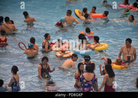 Peking, Peking, China. 8 Aug, 2018. Peking, China - Menschen genießen Sie die kühle am Wasser Park von Beijing National Aquatics Centre in Peking, China. Die Pekinger National Aquatics Center, auch als das Wasser Cube genannt, ist ein schwimmzentrum, die neben Peking Nationalstadion in der Olympischen Grün für die Schwimmwettbewerbe der Olympischen Sommerspiele 2008 errichtet wurde. Trotz seiner Spitznamen, das Gebäude ist nicht eine tatsächliche Cube, aber ein Quader (ein rechteckiger Kasten) Credit: SIPA Asien/ZUMA Draht/Alamy leben Nachrichten Stockfoto