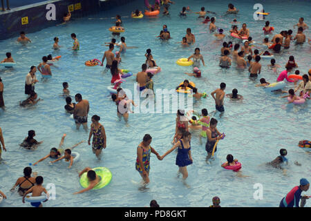 Peking, Peking, China. 8 Aug, 2018. Peking, China - Menschen genießen Sie die kühle am Wasser Park von Beijing National Aquatics Centre in Peking, China. Die Pekinger National Aquatics Center, auch als das Wasser Cube genannt, ist ein schwimmzentrum, die neben Peking Nationalstadion in der Olympischen Grün für die Schwimmwettbewerbe der Olympischen Sommerspiele 2008 errichtet wurde. Trotz seiner Spitznamen, das Gebäude ist nicht eine tatsächliche Cube, aber ein Quader (ein rechteckiger Kasten) Credit: SIPA Asien/ZUMA Draht/Alamy leben Nachrichten Stockfoto