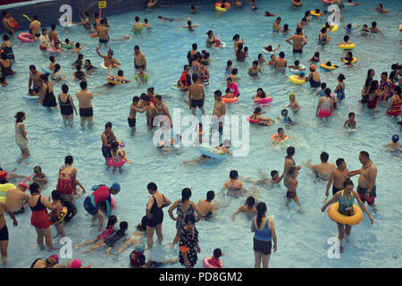 Peking, Peking, China. 8 Aug, 2018. Peking, China - Menschen genießen Sie die kühle am Wasser Park von Beijing National Aquatics Centre in Peking, China. Die Pekinger National Aquatics Center, auch als das Wasser Cube genannt, ist ein schwimmzentrum, die neben Peking Nationalstadion in der Olympischen Grün für die Schwimmwettbewerbe der Olympischen Sommerspiele 2008 errichtet wurde. Trotz seiner Spitznamen, das Gebäude ist nicht eine tatsächliche Cube, aber ein Quader (ein rechteckiger Kasten) Credit: SIPA Asien/ZUMA Draht/Alamy leben Nachrichten Stockfoto