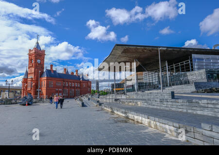 Bucht von Cardiff, Cardiff, Wales - Mai 20, 2017: Ansicht der Pierhead Building und Sinead mit Laufsteg vor. Menschen Flanieren auf dem Gehsteig auf einem Brig Stockfoto