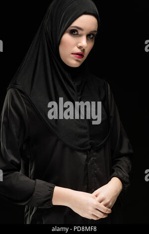 Porträt der schöne junge muslimische Frau mit schwarzen Hijab als konservativ Fashion Concept auf schwarzem Hintergrund Stockfoto