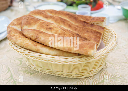 Frische hausgemachte Brot in einem weissen Korb. Frühstückstisch. Stockfoto