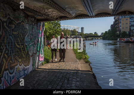 Paar Spaziergang unter einer Brücke über den Fluss Lea Navigation, Hackney Wick, East London, England, Vereinigtes Königreich, Europa. 2018 Stockfoto